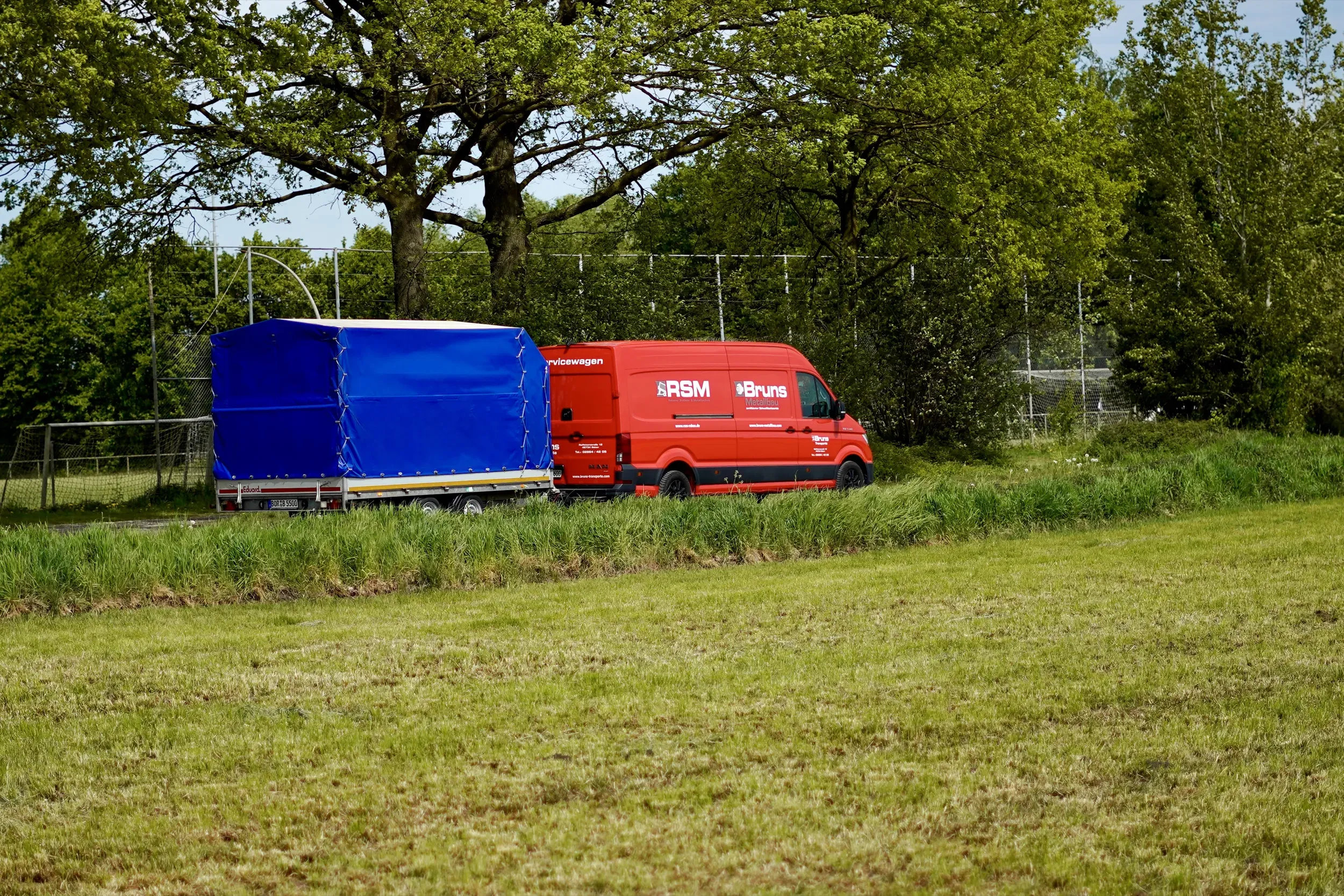 Planenanhänger und Transporter am Waldrand